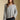 Front view of a woman wearing the Saltwater Luxe Kirra Sweater on a neutral background with hands at sides