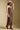 Side view of a woman wearing the Saltwater Luxe Laken Midi Dress on a neutral background with hand on brim of hat