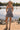 Front view of a woman wearing the Saltwater Luxe Leightyn Mini Dress with cowboy hat and boots in front of a lake