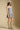 Side angle view of a woman wearing the Saltwater Luxe Leightyn Mini Dress on a neutral background with hat