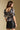 Back view of a woman wearing the Saltwater Luxe  Lemi Top on a neutral background with skirt