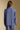 Back view of a woman wearing the Saltwater Luxe Liu Indigo Top on a neutral background with arms lowered