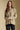Front view of a woman wearing the Saltwater Luxe Liu Top on a neutral background with hands clasped at waist