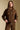 Front view of a woman wearing the Saltwater Luxe Long Sleeve Pullover on a neutral background with hands on hem