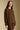 Side angle view of a woman wearing the Saltwater Luxe Long Sleeve Pullover on a neutral background with hands lowered