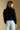 Back view of a woman wearing the Saltwater Luxe Louis Sweater on a neutral background with jeans