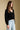 Side view of a woman wearing the Saltwater Luxe Louis Sweater on a neutral background with hands at sides