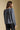 Back view of a woman wearing the Saltwater Luxe Lyrra Top on a neutral background with arms lowered