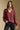 Front view of a woman wearing the Saltwater Luxe Lyrra Top on a neutral background with black pants and hand in pocket