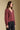 Side angle view of a woman wearing the Saltwater Luxe Lyrra Top on a neutral background with black pants