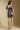 Back view of a woman wearing the Saltwater Luxe Malinda Mini Dress on a neutral background