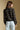 Back view of a woman wearing the Saltwater Luxe Margow Sweater on a neutral background with jeans