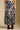 Front view of a woman wearing the Saltwater Luxe Maud Midi Floral Skirt on a neutral background with black boots