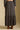 Back view of a woman wearing the Saltwater Luxe Maud Midi Skirt on a neutral background with arms at sides