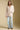 A full body front view of a woman wearing the Saltwater Luxe Maxine Simple Sweater on a neutral background