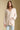 Front view of a woman wearing the Saltwater Luxe Maxine Simple Sweater on a neutral background with hand in pocket