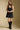 Front view of a woman wearing the Saltwater Luxe Miniya Mini Dress on a neutral background with hands clasped