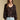 Front view of a woman wearing the Saltwater Luxe Nera Top on a neutral background with bluejeans and arms at sides