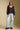 A full body front view of a woman wearing the Saltwater Luxe Nera Top on a neutral background