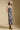 Front view of a woman wearing the Saltwater Luxe Novi Midi Dress and hat on a neutral background