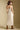 Back view of a woman wearing the Saltwater Luxe Peni Midi Dress on a neutral background