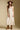 Front view of a woman wearing the Saltwater Luxe Peni Midi Dress on a neutral background with cowboy hat