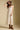 Front view of a woman wearing the Saltwater Luxe Peni Midi Dress on a neutral background with cowboy hat and boots