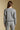 Back view of a woman wearing the Saltwater Luxe Perry Heather Grey Pullover on a neutral background with arms lowered
