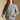 Frontview of a woman wearing the Saltwater Luxe Perry Heather Grey Pullover on a neutral background with arms on hem of shirt