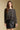 Front  view of a woman wearing the Saltwater Luxe on a neutral background with black skirt and hands at sides