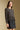 Side angle view of a woman wearing the Saltwater Luxe on a neutral background with skirt and hands at sides