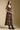 Front view of a woman wearing the Saltwater Luxe Quinlie Midi Dress on a neutral background with boots