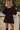 Front view of a woman wearing the Saltwater Luxe Ralph Mini Dress in front of water