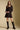 Front view of a woman wearing the Saltwater Luxe Ralph Mini Dress on a neutral background with black knee-high boots
