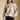 Front of a woman wearing the Saltwater Luxe Ronnie Sweater on a neutral background with black pants with one hand in pocket