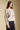 Side angle view of a woman wearing the Saltwater Luxe Ronnie Sweater on a neutral background with black pants