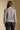 Back view of a woman wearing the Saltwater Luxe Saskia Sweater on a neutral background with black pants