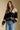 Front view of a woman wearing the Saltwater Luxe Scarlit Sweater on a neutral background with hand in pocket