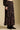 Side angle view of a woman wearing the Saltwater Luxe Selah Midi Skirt on a neutral background with hands at sides