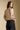 Back of a woman wearing the Saltwater Luxe Slaide Sweater on a neutral background looking over one shoulder