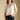 Front view of a woman wearing the Saltwater Luxe Stacia Top on a neutral background with hand in pants pockets