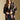 Front view of a woman wearing the Saltwater Luxe Stari Sweater on a neutral background with hands clasped and jeans