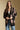 Front view of a woman wearing the Saltwater Luxe Stari Sweater on a neutral background with hands clasped and jeans
