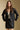 Front view of a woman wearing the Saltwater Luxe Sylvie Jacket and matching skirt on a neutral background with hands on hips