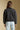 Back view of a woman wearing the Saltwater Luxe Tamira Jacket on a neutral background with arms at sides
