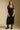 Front  view of a woman wearing the Saltwater Luxe Tamra Midi Dress on a neutral background with hands at sides
