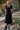 Front  view of a woman wearing the Saltwater Luxe Tamra Midi Dress on an outdoor staircase