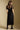 Back view of a woman wearing the Saltwater Luxe Tamra Midi Dress on a neutral background
