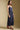 Side view of a woman wearing the Saltwater Luxe Tarynel Maxi Dress on a neutral background with shoes