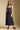 Front view of a woman wearing the Saltwater Luxe Tarynel Maxi Dress on a neutral background with sneakers